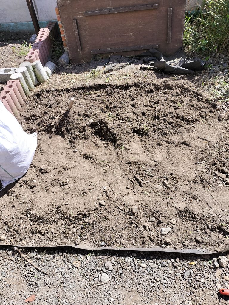 三本爪のミニ熊手で土をほぐしながら草の根を取る様子
