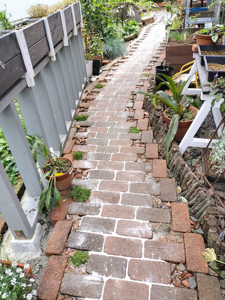 余分な珪砂をほうきで落としたレンガの小道