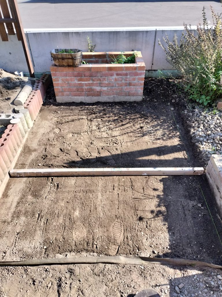 長い木材を使ってコンポスト前の地面をならす整地作業
