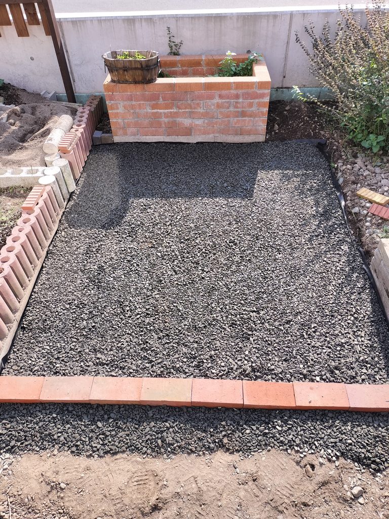 防草シートと砕石を敷き手前にレンガを並べて整えたコンポスト前